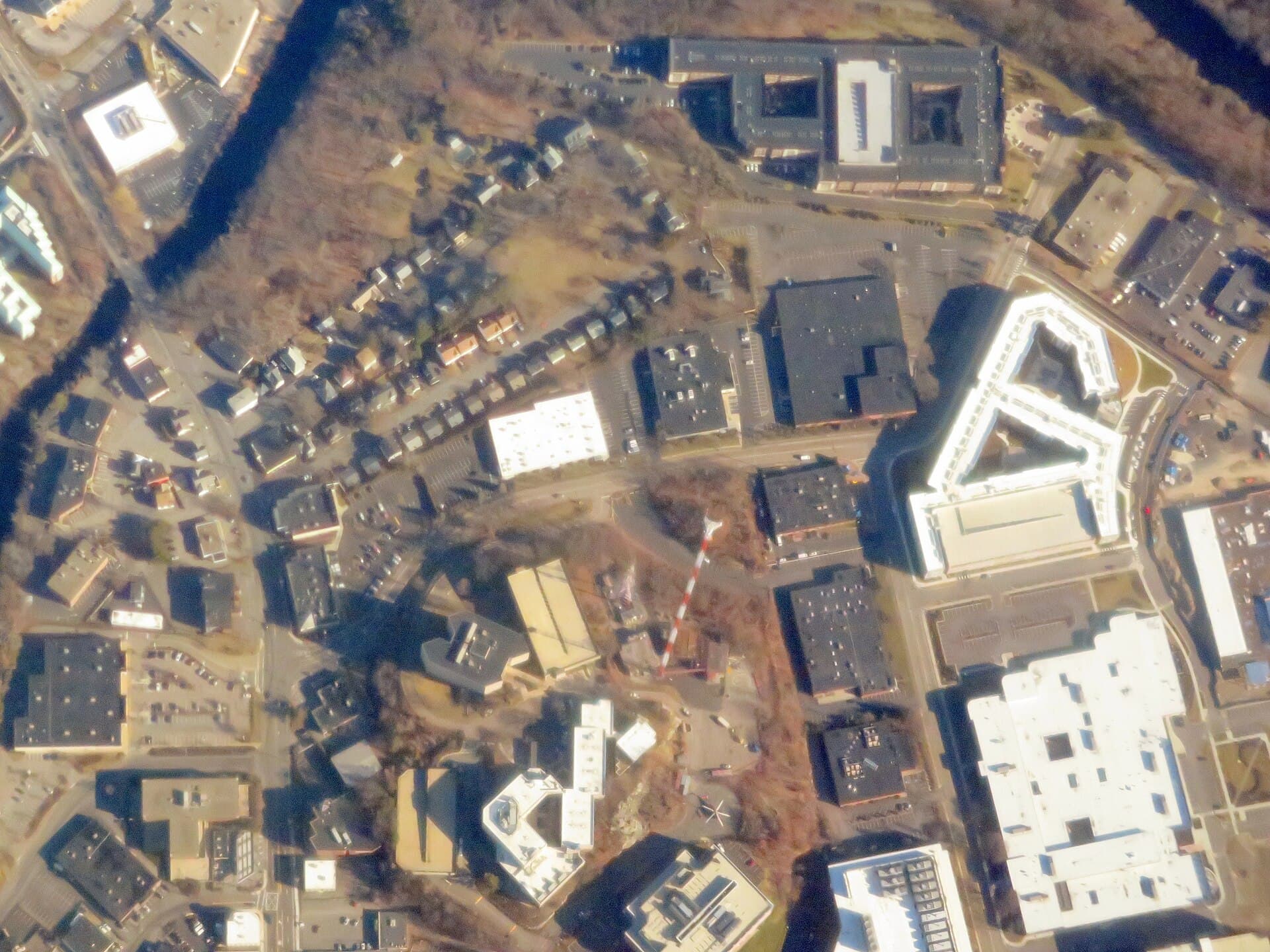 A top-down aerial view over the flat roofs of a business park