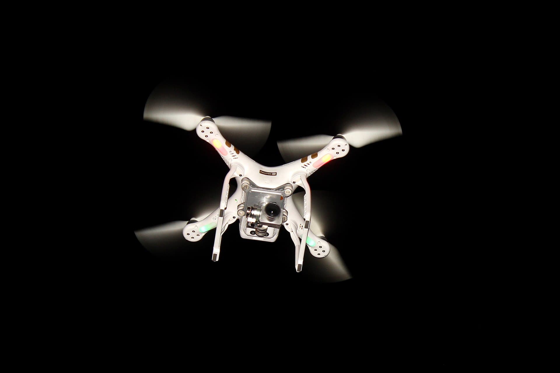 A quadcopter in flight with its camera gimbal visible