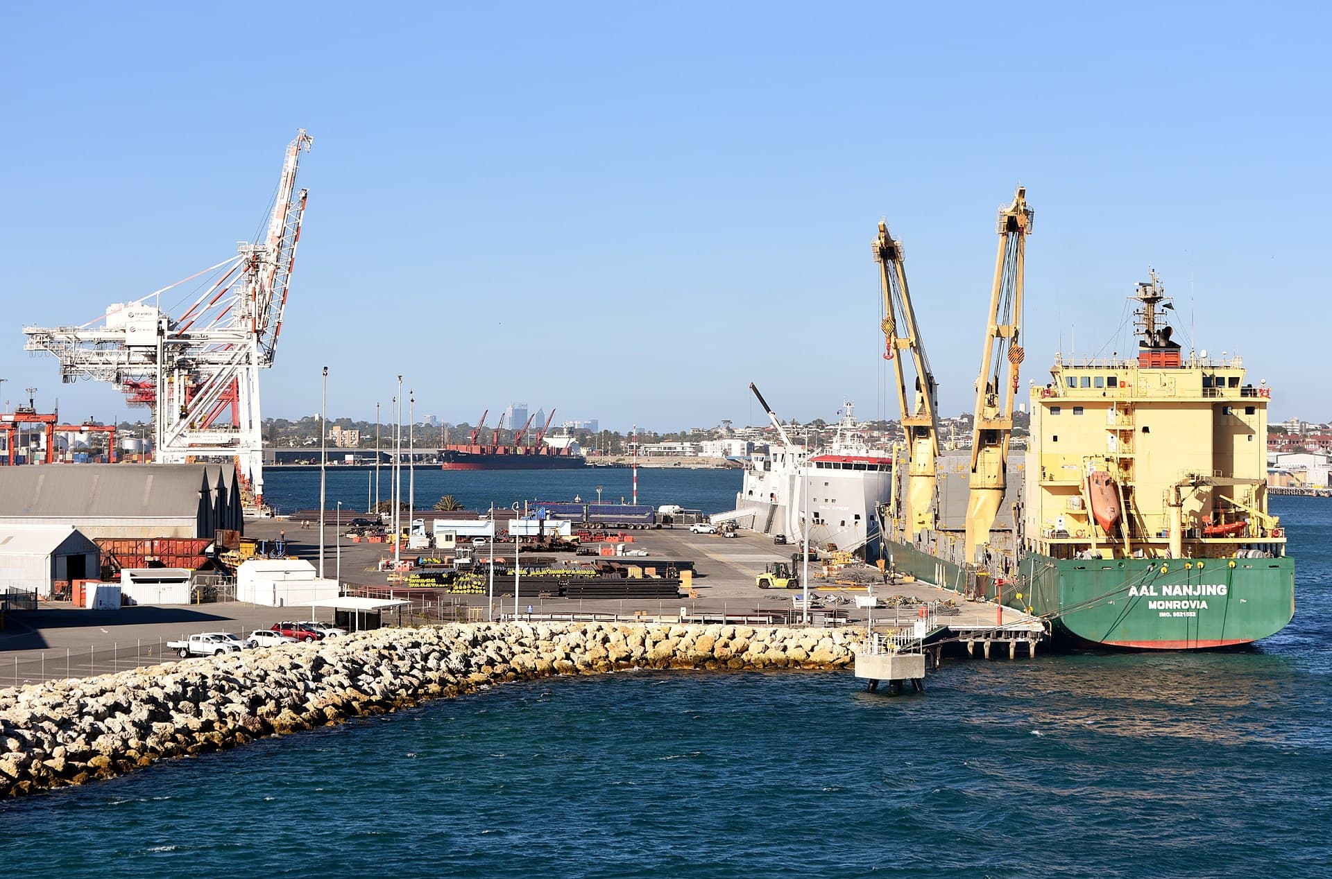 A working quay with a gantry crane and a general cargo ship at berth